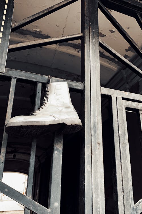 Brown Leather Boots Hanged on Metal Gate