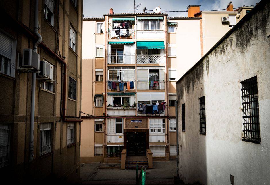 Vista exterior de un edificio de apartamentos en la ciudad con ropa tendida, capturando la esencia de la vida urbana.