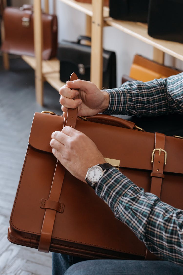 A Person Holding A Brown Leather Briefcase