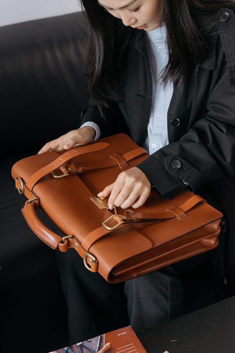 A Woman Checking Brown Leather Briefcase