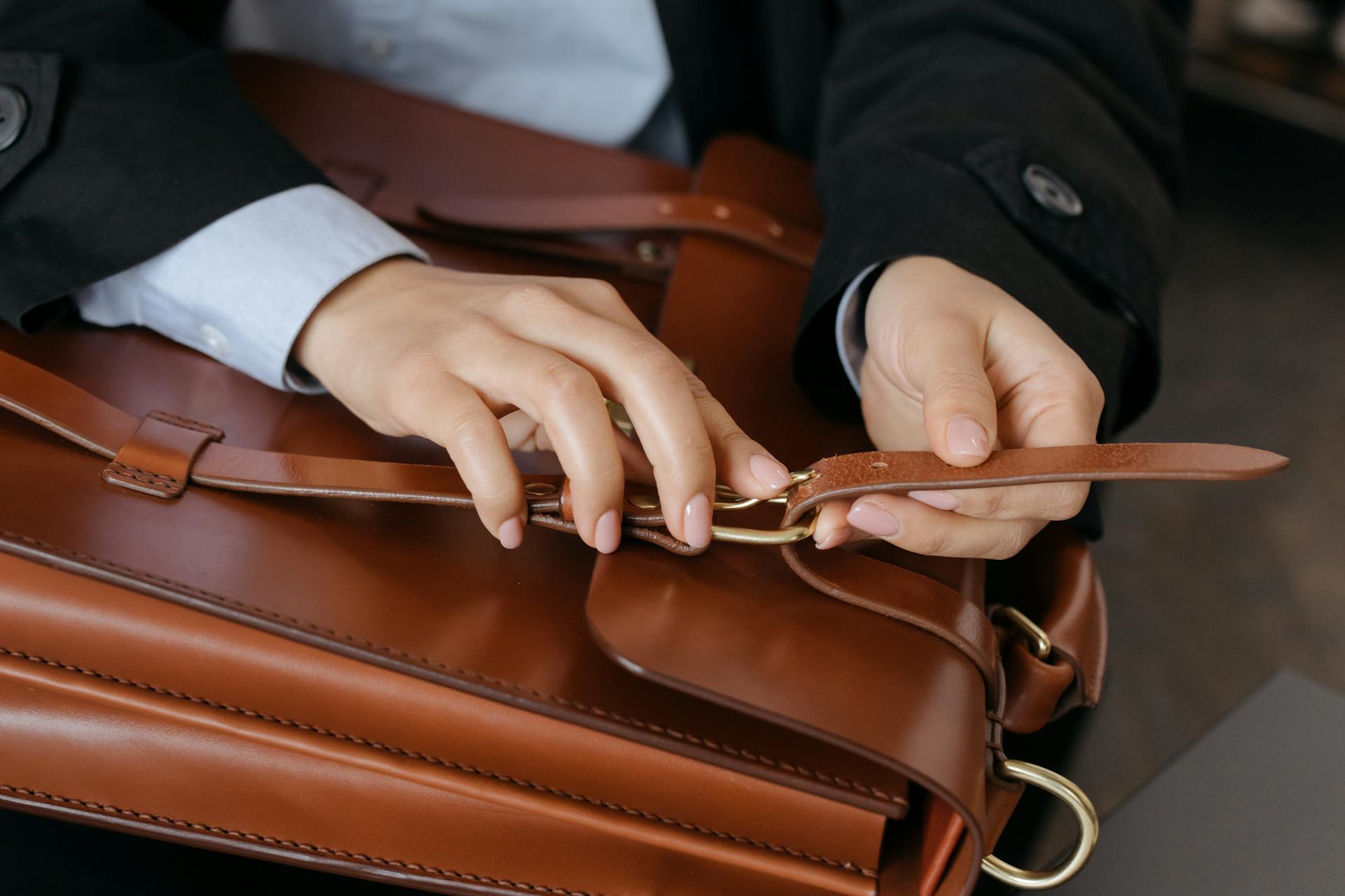 A Person on Black Blazer Holding Brown Leather Bag