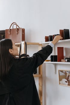 Woman browsing leather bags and wallets in a stylish retail shop.