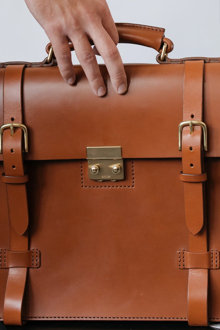 Person Holding Brown Leather Bag