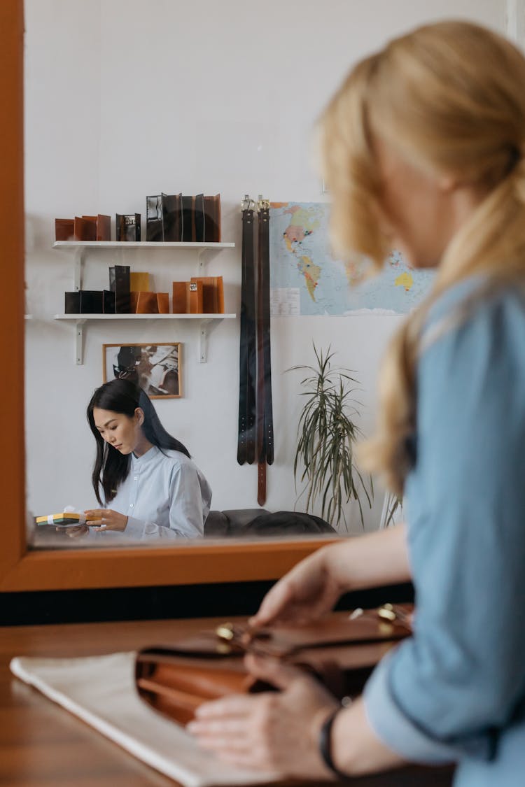 A Mirror Image Of A Woman Holding A Gift Box