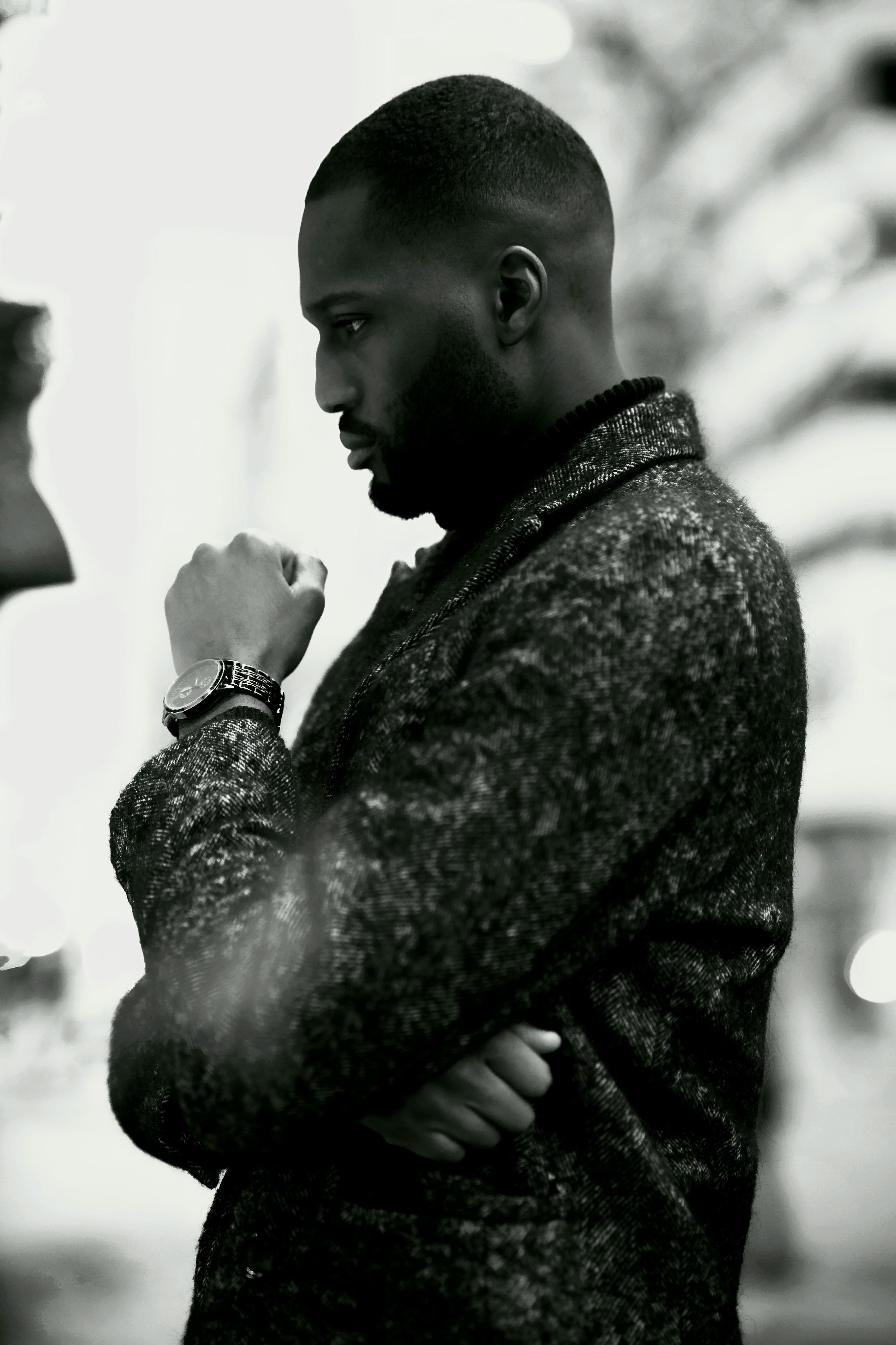 Black and white image of a thoughtful man in a textured jacket, Ottawa.