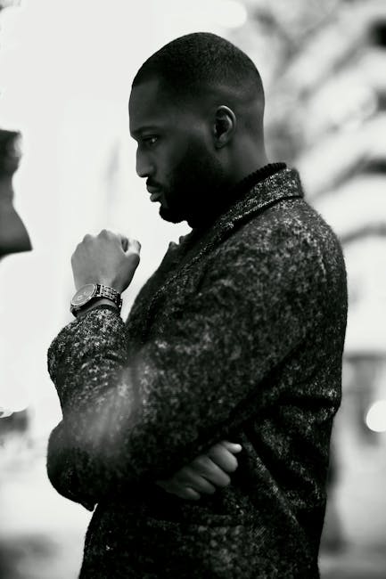 Black and white image of a thoughtful man in a textured jacket, Ottawa.