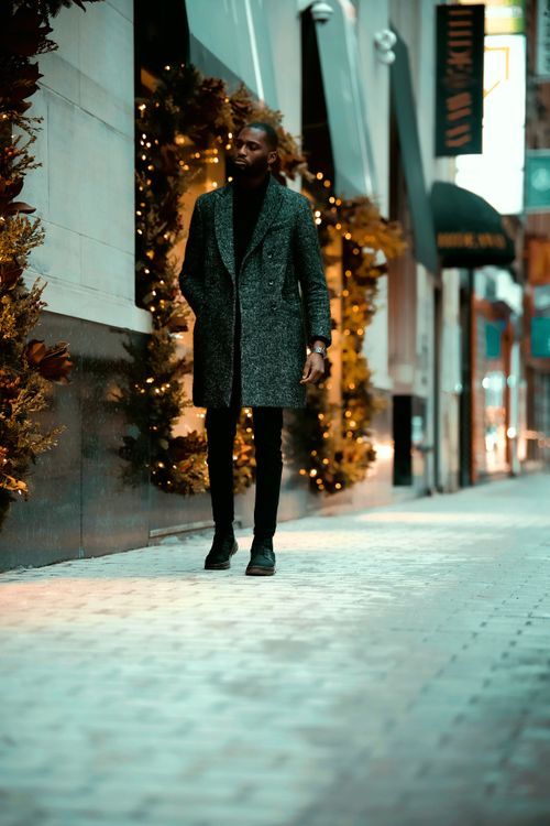 Free Man in coat walking on a decorated street with festive lights in Ottawa. Stock Photo