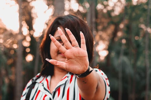 Free Woman Wearing Striped Shirt with Hand Reaching Out Stock Photo