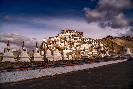 Scenic landscape of a Tibetan monastery with striking architecture against a dramatic sky.