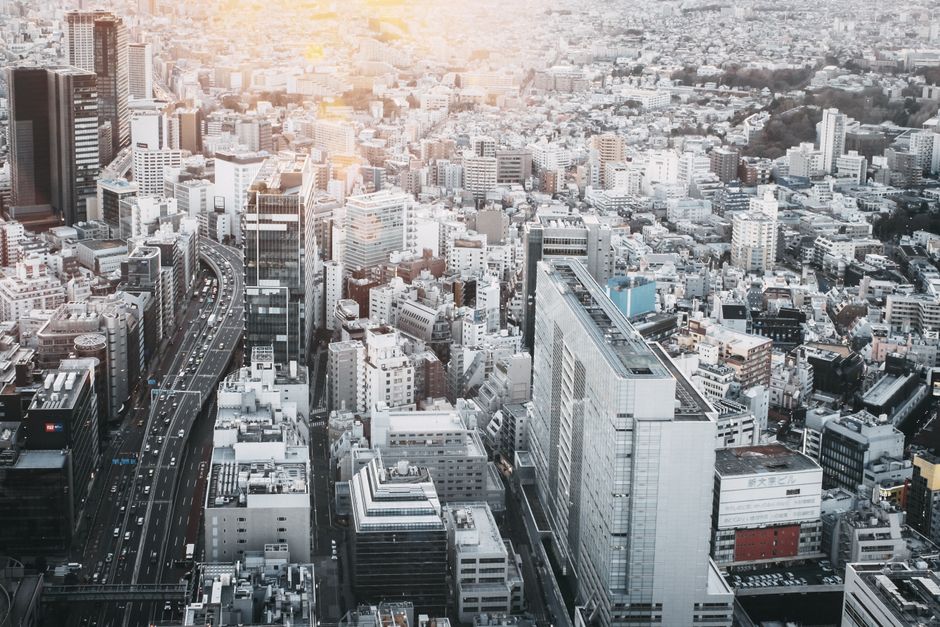 温かい夕日の光で照らされた東京の密集した都市風景の魅力的な空撮。