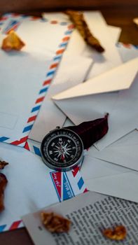 A scene featuring a compass, envelopes, and autumn leaves, capturing a nostalgic and exploratory mood.
