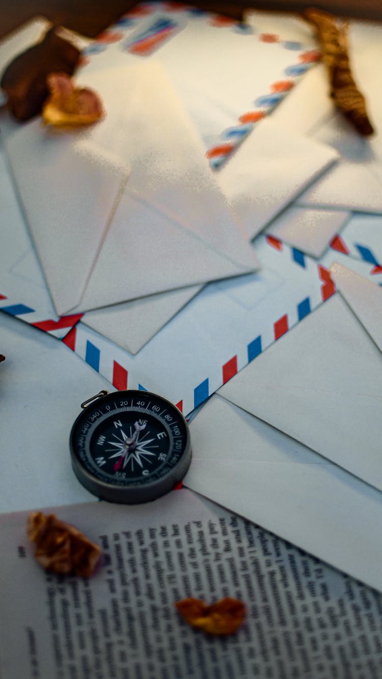 A Compass And Mail Envelopes On The Table