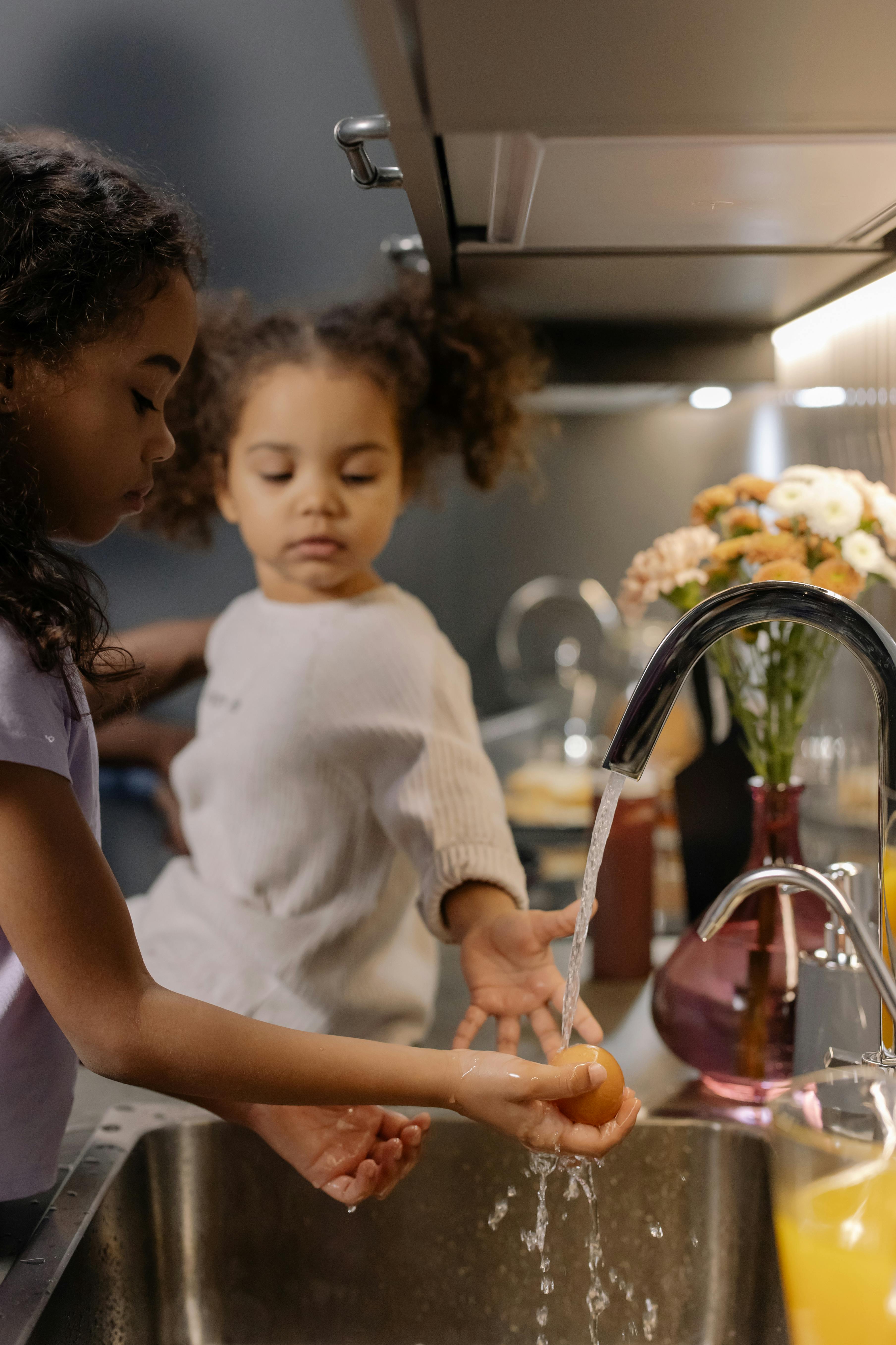Girls Washing an Egg on Running Water