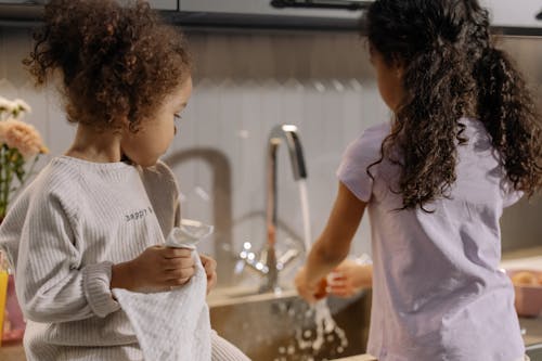 Free Back View of Sisters Helping in Household Chore Stock Photo