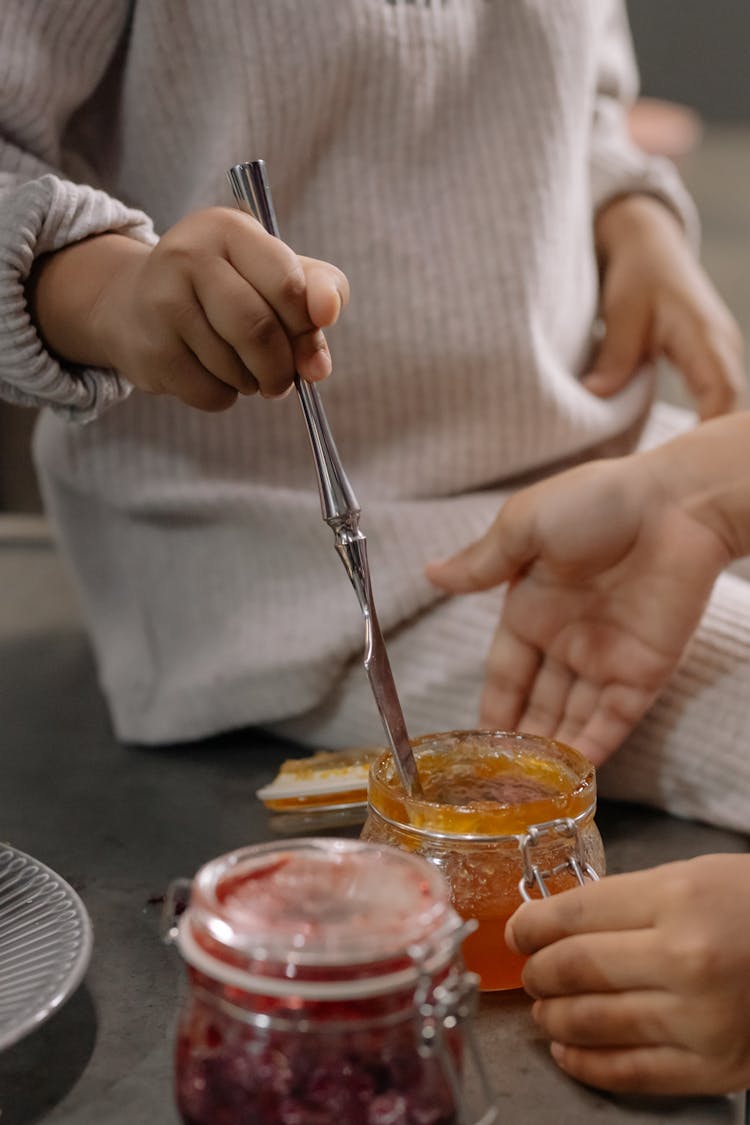 Close-Up Shot Of A Kid Getting A Jam From A Jar