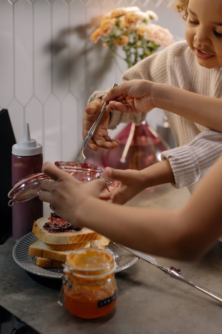 Close-Up Shot Of A Child Helping In Making Of Sandwiches