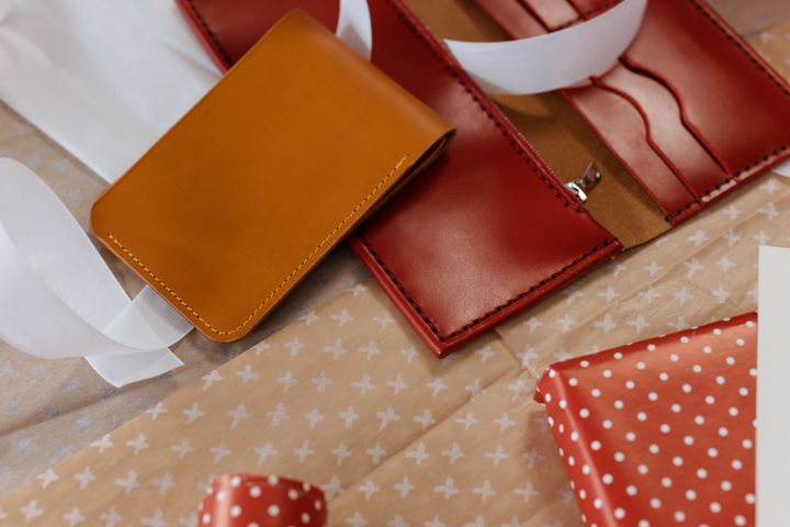 Tan and red leather wallets with ribbon and wrapping paper — photo by cottonbro studio on Pexels