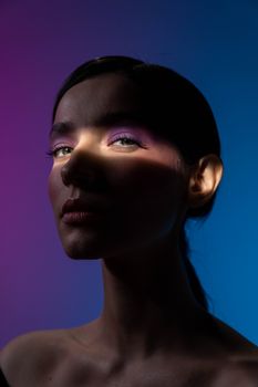 Artistic portrait of a woman with colorful lighting creating a moody atmosphere.