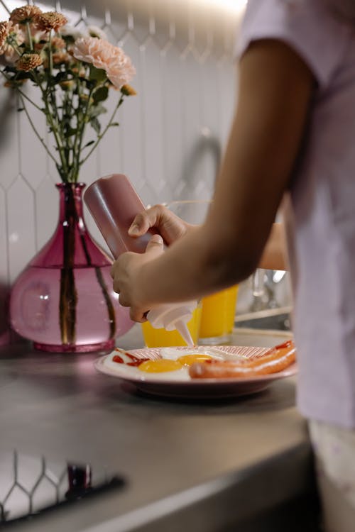 Free A Kid Squeezing a Ketchup Bottle Stock Photo