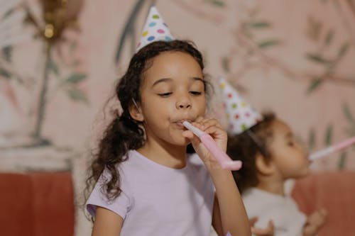 Free Girl Wearing Party Hat Blowing Party Horn Stock Photo