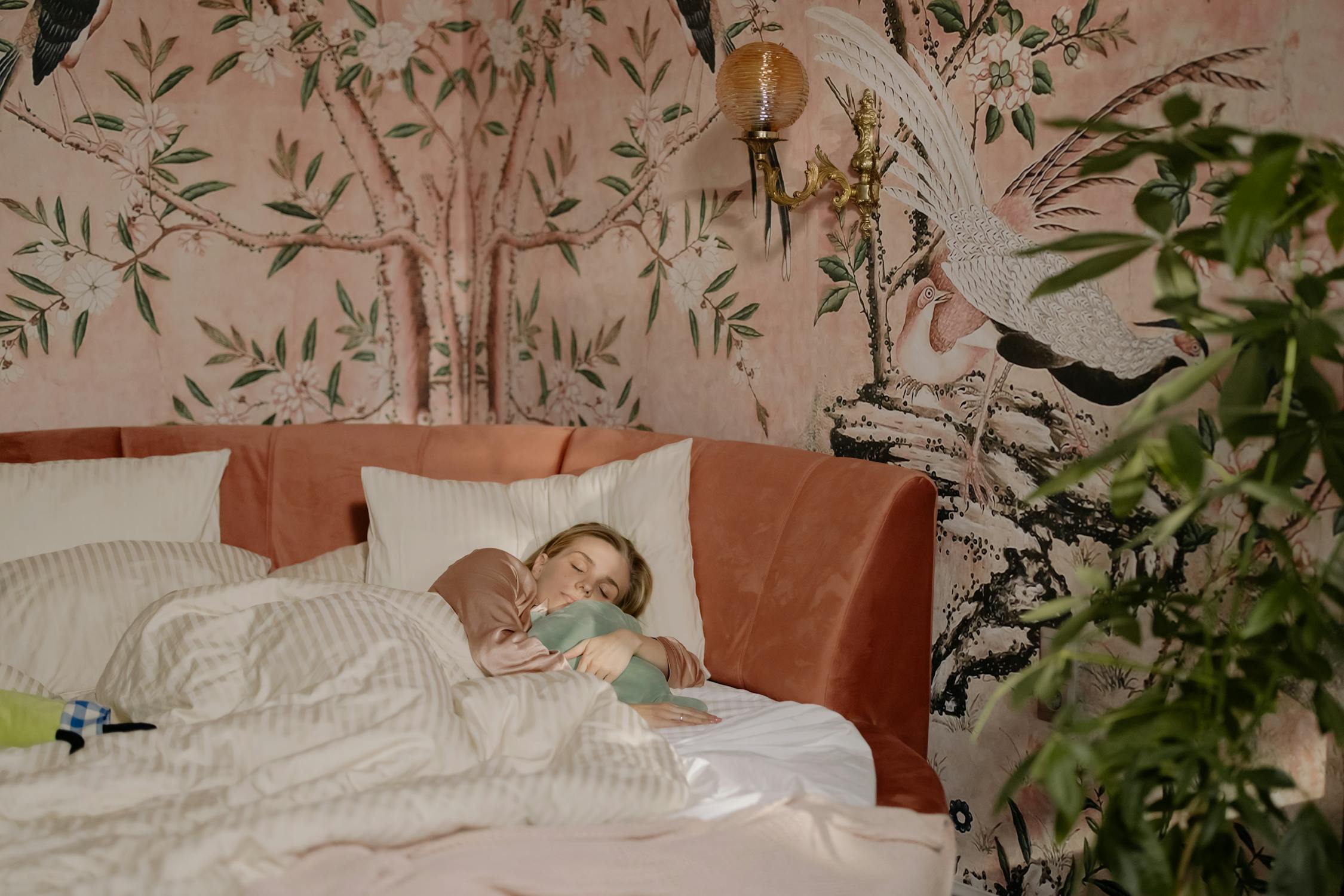 Image of a woman sleeping in bed hugging a pillow