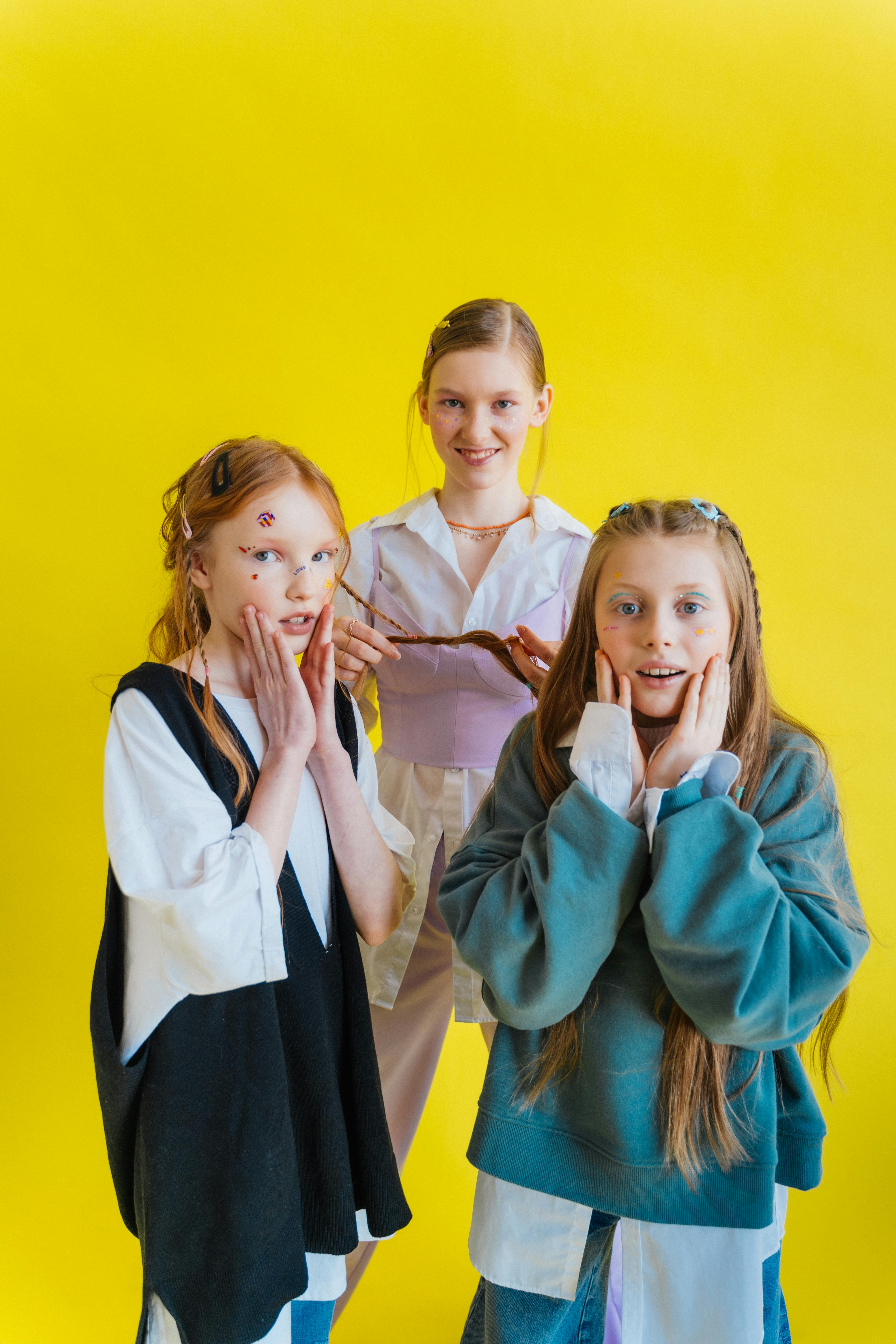 three girls standing on yellow background