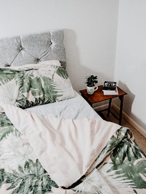 Free Bed with Green Leaves Comforter Stock Photo