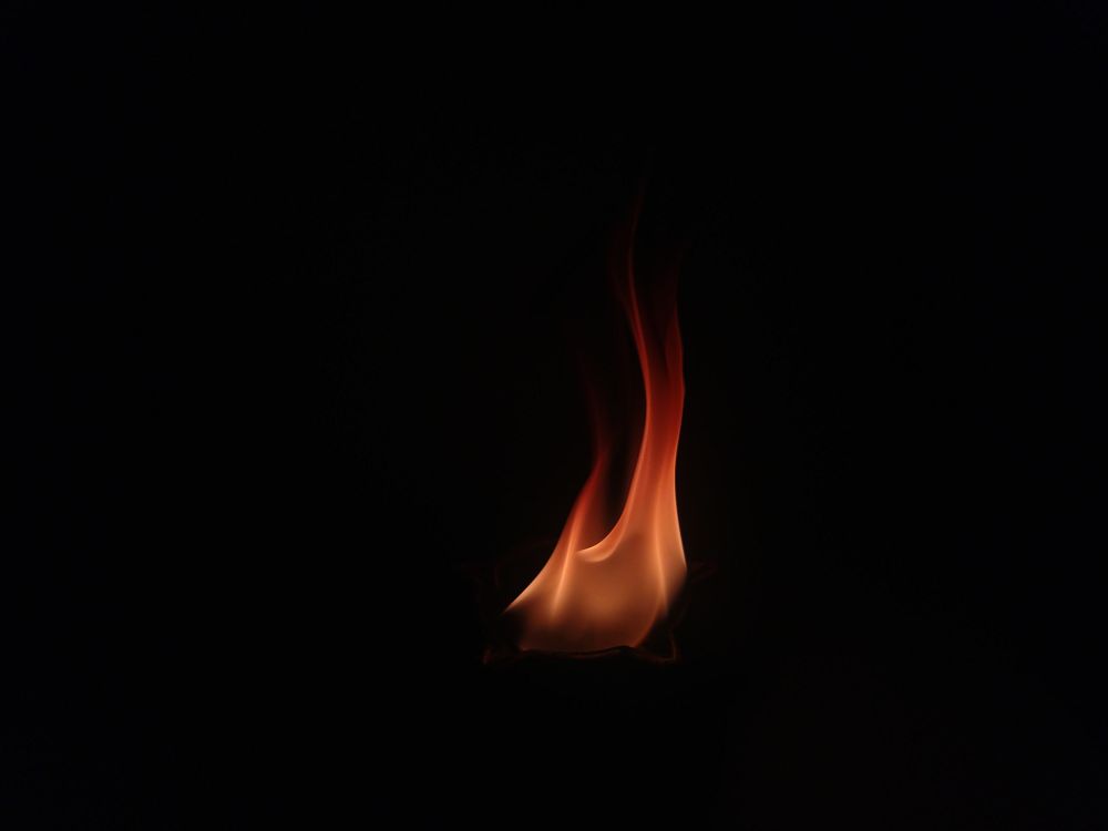Wallpaper hitam aesthetic api kecil di kegelapan