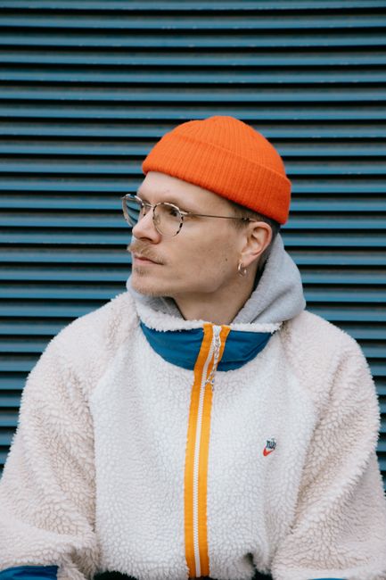 Stylish man in an orange beanie and eyeglasses in Belgium