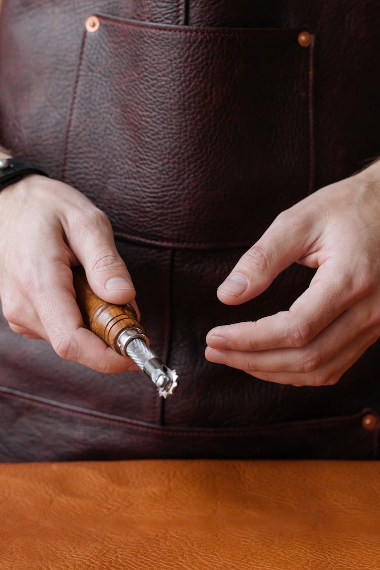 Close-Up Shot Of A Person Holding A Leather Workshop Tool