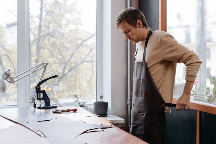 Man Putting On Leather Apron