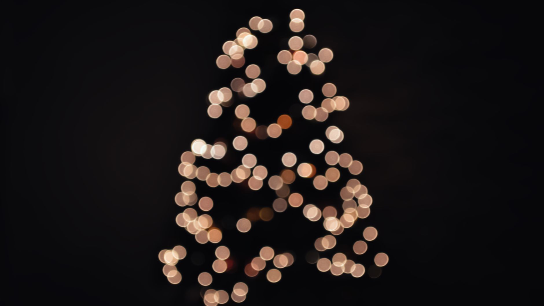 Abstract image of Christmas tree shaped bokeh lights glowing against a dark background. — free online jigsaw puzzle on JigsawPuzzlesFreeOnline.org