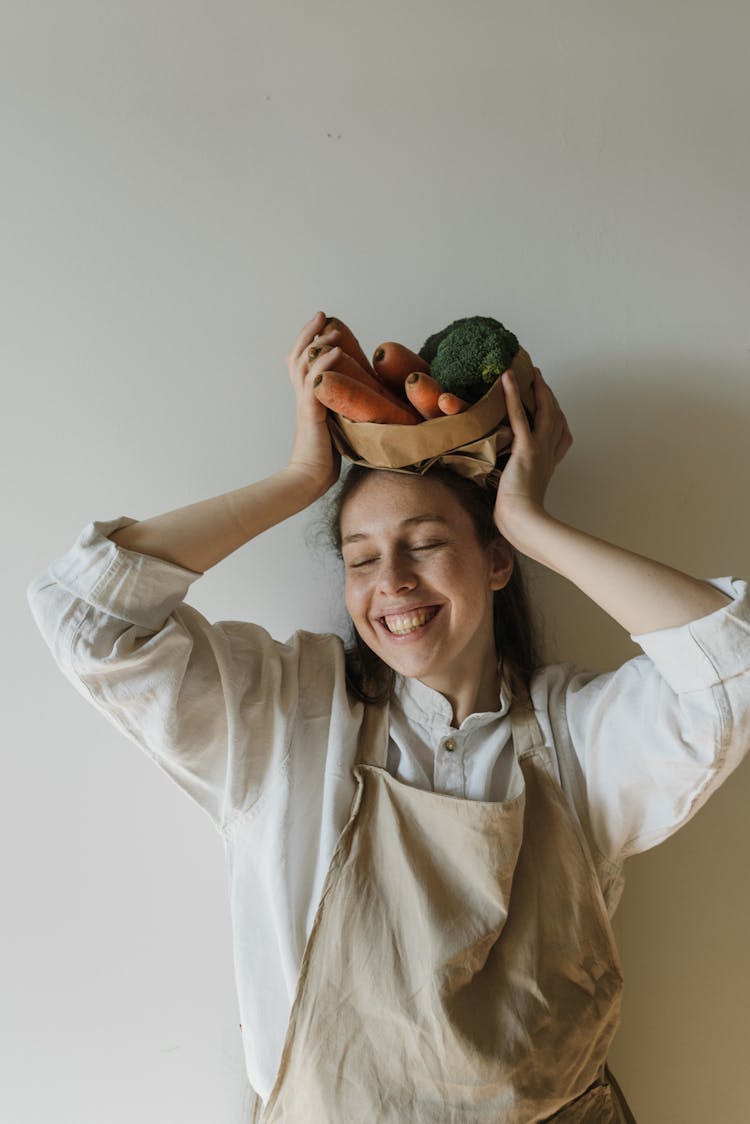 A Happy Woman Holding Assorted Vegetables