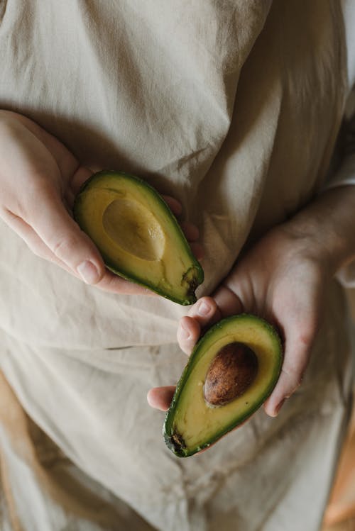 A Person Holding Slices of Avocado
