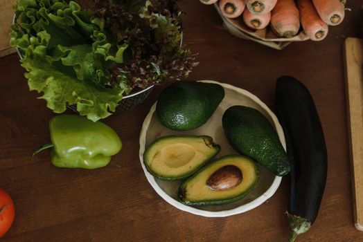 Top view of fresh vegetables and avocado on a wooden table enhancing healthy eating.