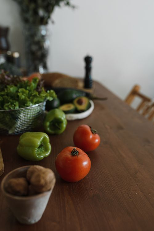 Free A selection of fresh vegetables including tomatoes and bell peppers on a wooden table. Stock Photo