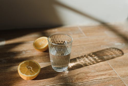 Free Sliced Lemon Beside a Drinking Glass Stock Photo