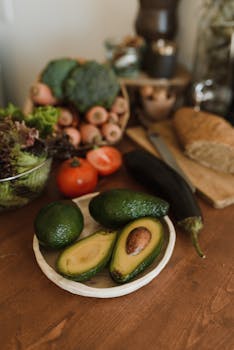 Rustic kitchen setup featuring fresh avocados, vegetables, and whole grain bread for a healthy meal preparation.