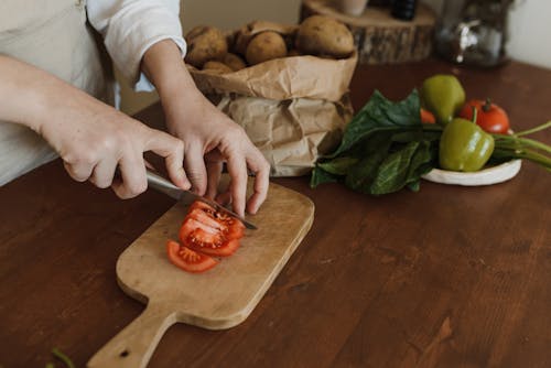 Close Up Shot of a Person Slicing Tomato with a Knife
