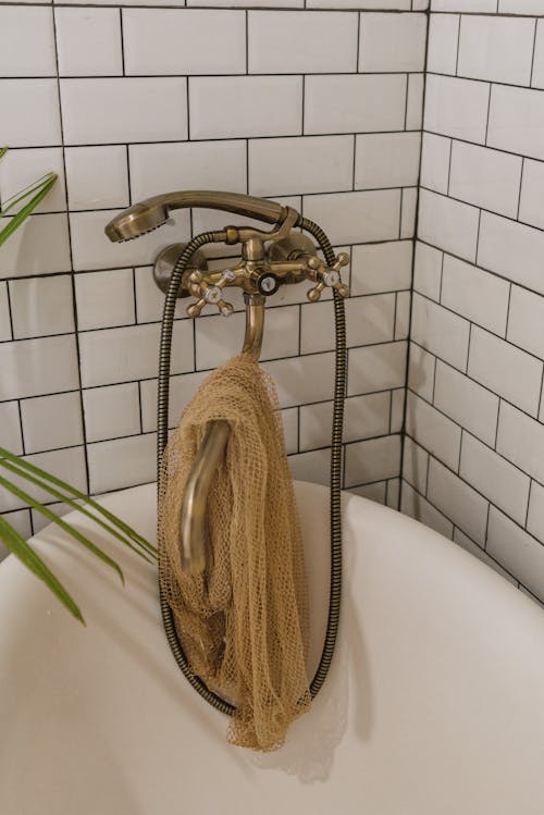 Free A Bronze Shower Head and Faucet Over a Bathtub Stock Photo