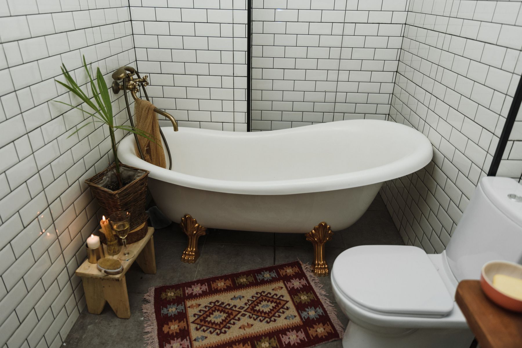 Bathroom with classic tub and rug placed over hard flooring in a drier zone
