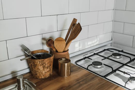 A stylish kitchen counter featuring wooden utensils and a gas stove.