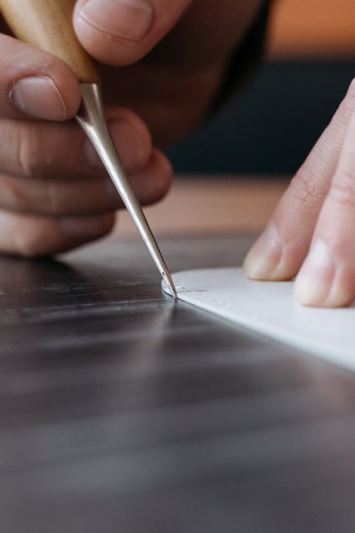 Man Using Art Tools Close-up of Man Using a Sharp Tool on a Black Surface · Free Stock Photo