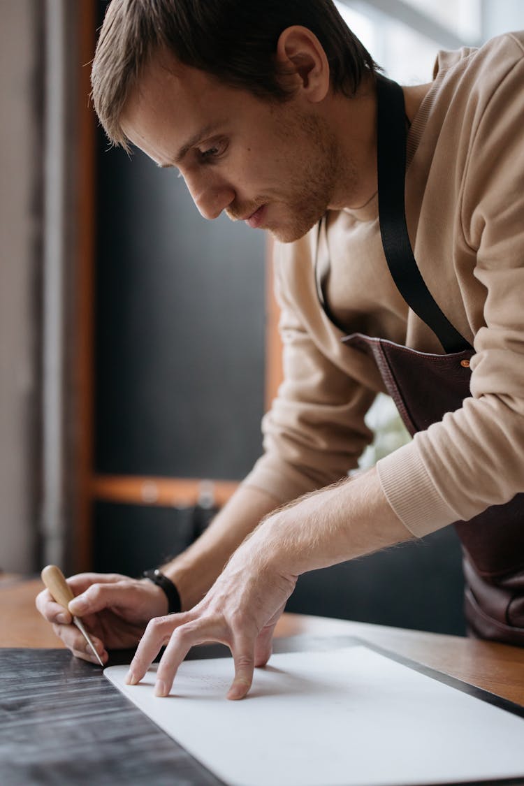 A Man Holding A Chisel And A White Board