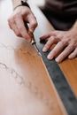 A Person Scraping a Wood with a Chisel