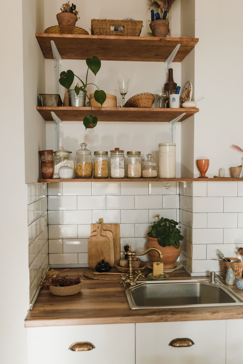 Open kitchen shelves with glass storage jars above a tiled counter, photo by Arina Krasnikova on Pexels