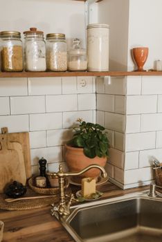A cozy rustic kitchen setup with a brass faucet and decorative elements.