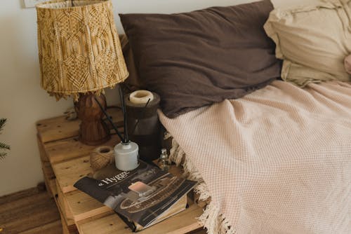A Bed Beside a Jar  with Incense Over a Magazine