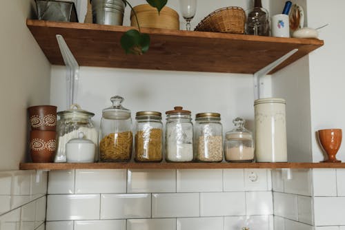 Glass Jars on a Wooden Shelf in a Kitchen