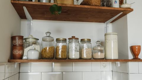 Aesthetic kitchen shelves displaying various jars and containers for organized storage.